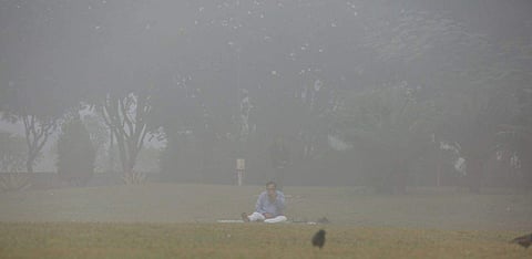 A man practices yoga amidst heavy smog conditions in New Delhi. (Shekhar Yadav | EPS)