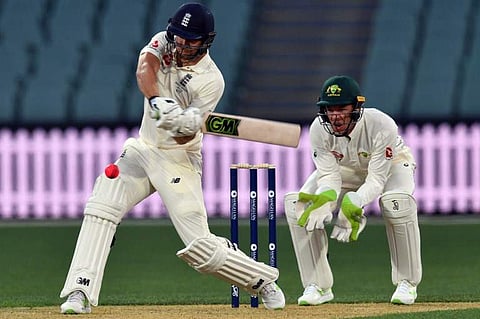 England's batsman Dawid Malan plays a shot as Cricket Australia XI's wicketkeeper Tim Paine (R) looks on during the first day of a four-day Ashes tour match at the Adelaide Oval.|AFP