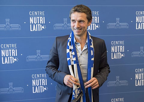 Remi Garde, the new head coach of the Montreal Impact, poses with a scarf during an MLS soccer news conference in Montreal, Wednesday, Nov. 8, 2017. | AP