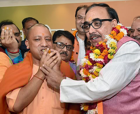 Uttar Pradesh Chief Minister Yogi Adityanath and BJP state president Mahendra Nath Pandey celebrate the victory of the party in the state civic body elections at the party office in Lucknow on Friday. | PTI