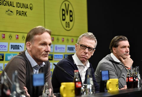 Borussia Dortmund CEO Hans-Joachim Watzke, left, and sporting manager Michael Zorc, right, present Austrian coach Peter Stoeger, center, as the new head coach of the Bundesliga soccer club. | AP