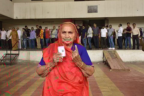 A voter showing her inked finger at a polling booth during Gujarat assembly election in Surat on Saturday. (PTI Photo)