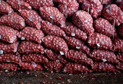 Packed sacks of onions kept for delivery are seen at an empty wholesale fruit and vegetable market in Pimpalgaon. (Photo | Reuters)