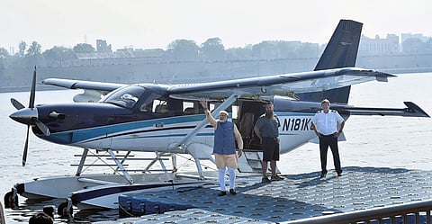 Prime Minister Narendra Modi waves to the crowd as he boards a seaplane on the Sabarmati river front in Ahmedabad on Tuesday. | PTI