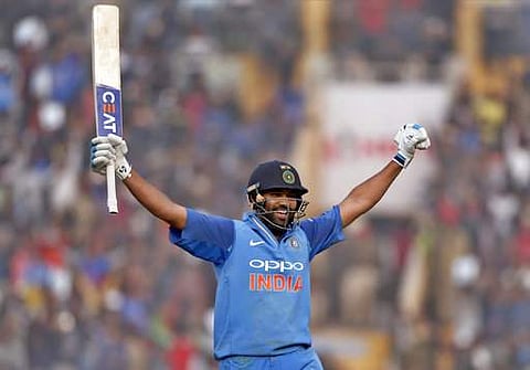 India's captain Rohit Sharma raises his bat to celebrate scoring a double century during their second one-day international cricket match against Sri Lanka in Mohali, India. (AP)
