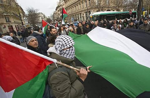 Demonstrators hold a Palestinian flag as they stage a protest against U.S. President Donald Trump's decision to recognize Jerusalem as the capital of Israel in Paris, France, Sunday, Dec. 17, 2017. | AP