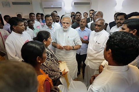 Prime Minister Narendra Modi interacting with family members of fishermen family affected by Cyclone Ockhi in Kanyakumari on Tuesday. Tamil Nadu Chief Minister Edappadi K. Palaniswami and others also seen. (Photo: PTI)