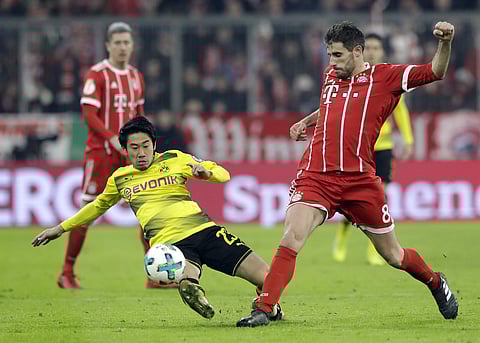 Bayern's Javi Martinez and Dortmund's Shinji Kagawa challenge for the ball during the round of sixteen German Cup match | AP
