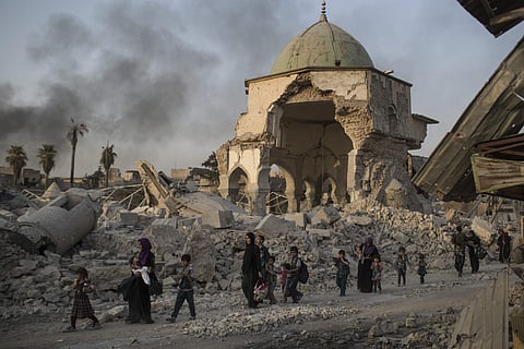 Civilians walk past the destroyed al-Nuri mosque as Iraqi forces continue their advance against IS militants in the Old City of Mosul | AP