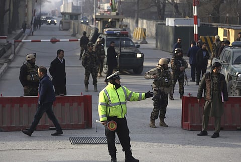 Afghan traffic police and security personnel stand near the site of a suicide attack in Kabul, Afghanistan, Monday, Dec. 25, 2017. (Associated Press)