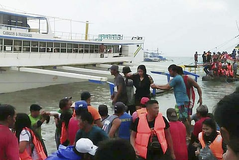 Rescued passengers from the ill-fated M/V Mercraft 3 disembark from a boat which helped in the rescue operation at Infanta township, Quezon province in northeastern Philippines Thursday, Dec. 21, 2017. (Associated Press)