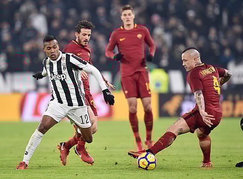 Juventus' Alex Sandro, left, and Roma's Radja Nainggolan vie for the ball during the Italian Serie A soccer match in Turin, Italy, Saturday, Dec. 23, 2017. | AP