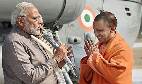 Prime Minister Narendra Modi being received by the Chief Minister of Uttar Pradesh Yogi Adityanath on his arrival at Botanical Garden in Noida. (PTI)