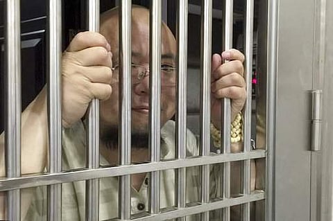 Wu Gan also known as the Ultra Vulgar Butcher is seen behind bars at police station in Nanchang city in eastern China's Jiangxi province.(File | AP)