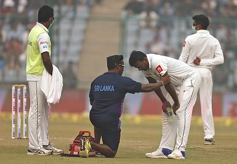 A paramedic speaks to Sri Lanka's Lahiru Gamage after he complained of short of breath during the second day of a third Test match against India in New Delhi, India, Sunday, Dec. 3, 2017. | AP