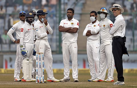 Sri Lanka's Dilruwan Perera, center, and teammates wait for third umpire decision for the wicket of India's Cheteshwar Pujara during the fourth day of their third Test match in New Delhi, India, Tuesday, Dec. 5, 2017. | AP
