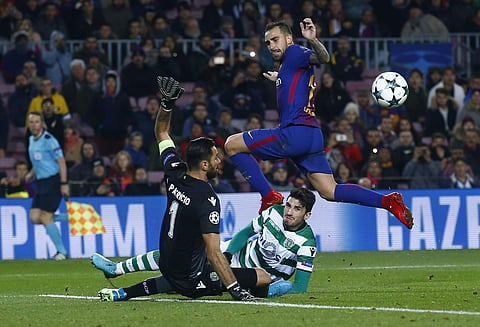 Barcelona's Paco Alcacer, up, jumps over Sporting goalkeeper Rui Patricio, left, during the Champions League Group D soccer match between FC Barcelona and Sporting CP at the Camp Nou stadium in Barcelona. | AP