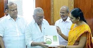 Mayor Soumini Jain handing over a copy of the green calendar, brought out by KMRL , to  former mayor Hamsakunju