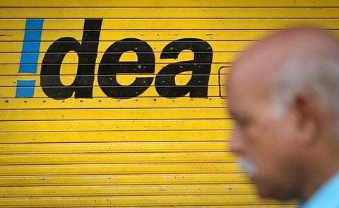 A man walks past a shop displaying Idea Cellular Ltd's logo on its shutters in Mumbai. (File photo | REUTERS)