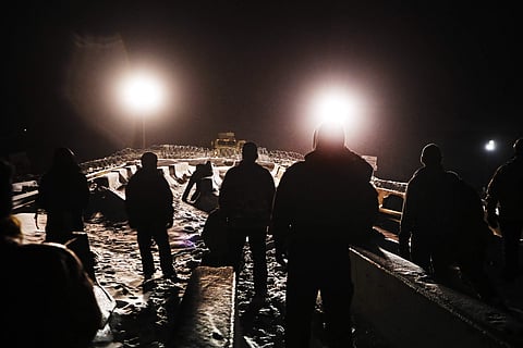 Military veterans walk onto a closed bridge to protest the Dakota Access oil pipeline across from police protecting the site in Cannon Ball. (File photo | AP)