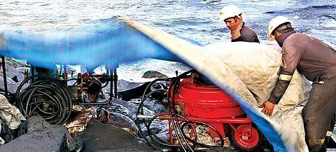 Workers removing oil sludge from the sea in Ennore on Wednesday | romani agarwal