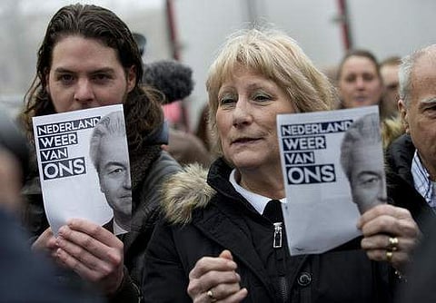 People hold flyers bearing the portrait of firebrand int-islam lawmaker Geert Wilders reading 'Netherlands Again Ours' during an election campaign near Rotterdam, Netherlands, Saturday Feb. 18, 2017. (Photo | AP)