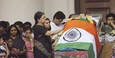 V K Sasikala stands next to the mortal remains of J Jayalalithaa at Rajaji Hall in Chennai
