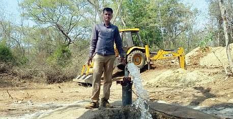 Forest staffer filling water in a waterhole for wild animals | Express
