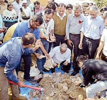 Union drinking and sanitation secretary Parameswaran Iyer removing the waste from one of the pits in Gangadevipally village in Warangal on Saturday | Express