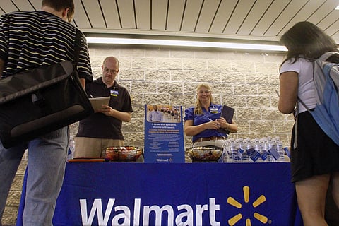 In this Sept. 1, 2011, photo, Wal-Mart employees Jon Christians and Lori Harris take job applications and answers questions during a job fair at the University of Illinois Springfield campus in Springfield, Ill.  | AP