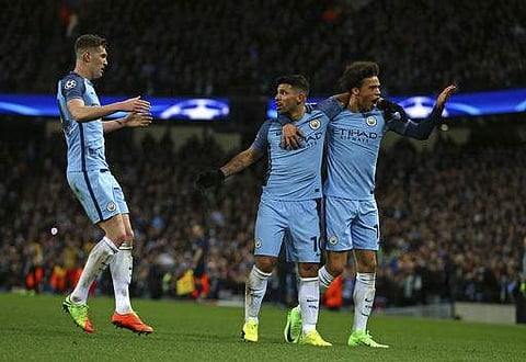 Manchester City's Sergio Aguero, center, celebrates with Leroy Sane, right, and John Stones after scoring his side's third goal during the Champions League round of 16 first leg. | AP
