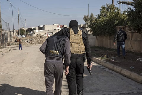 An Iraqi security officer holds an Islamic State group suspect after arresting him, in eastern Mosul, Iraq. (Photo | AP)