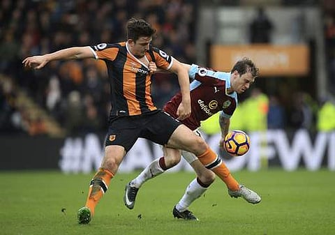 Hull City's Harry Maguire, left, and Burnley's Ashley Barnes battle for the ball during their English Premier League soccer match at the KCOM Stadium. | AP