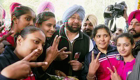 PPCC President Capt Amrinder Singh flashes victory sign with youngsters at a polling station during voting for Punjag Assembly polls in Patiala on Saturday. | PTI