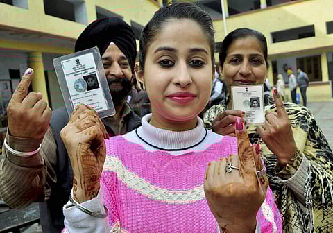 A girl along with her family members showing indelible ink mark on her finger after casting vote during the Assembly Election at a polling station in Patiala on Saturday. | PTI