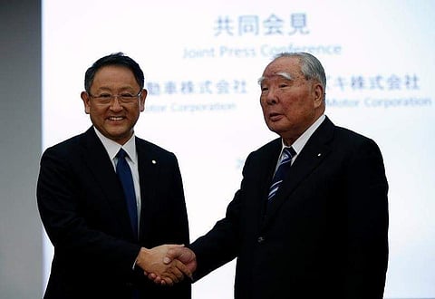 Toyota Motor Corp President Akio Toyoda (L) shakes hands with Suzuki Motor Chairman and CEO Osamu Suzuki at their joint news conference in Tokyo, Japan, October 12, 2016. REUTERS