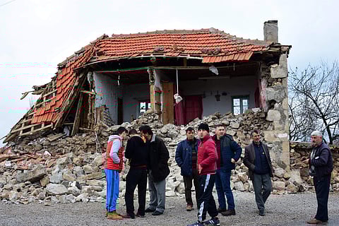 Villagers stand in front of a damaged house after two quakes, both jolted Turkey's northern Aegean coast, in Yukarikoy village Canakkale province, Monday, Feb. 6, 2017 (Photo | AP)