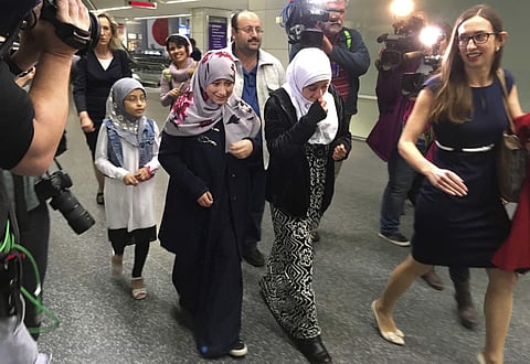 Eman Ali, 12, second from left, walks with her father, Ahmed Ali, center, after they arrived at San Francisco International Airport, Sunday, Feb. 5, 2017, in San Francisco. Joining them is her sister Salma Ali, 14, second from right, her cousin, left, who