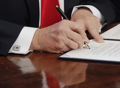 In this Feb. 3, 2017, photo, President Donald Trump signs an executive order in the Oval Office of the White House in Washington. Reality took a beating from the Washington blame game this past week.  | AP