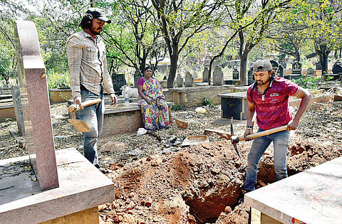 Her younger sons Rajkumar and Puneeth Kumar digging a grave