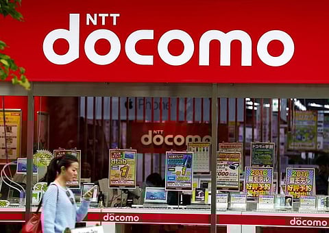 A woman walks past a brach of Japanese mobile communications company NTT Docomo in Tokyo, Japan. (Reuters)