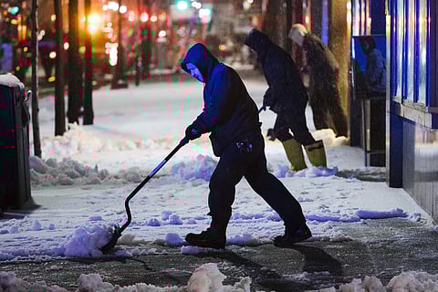 Workmen clear a sidewalk during a winter storm in Philadelphia