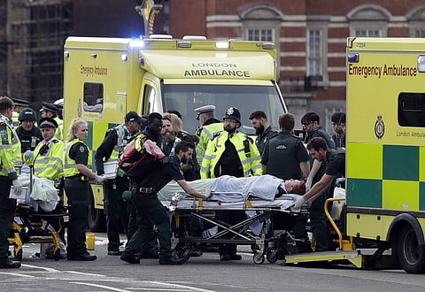 Emergency services transport an injured person to an ambulance, close to the Houses of Parliament in London, March 22, 2017. AP