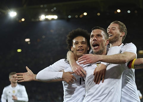 Germany's Lukas Podolski celebrates with his teammates Leroy Sane, left, and Andre Schuerrle, right, after scoring the opening goal during the friendly soccer match between Germany and England in Dortmund, Germany, Wednesday, March 22, 2017. | AP