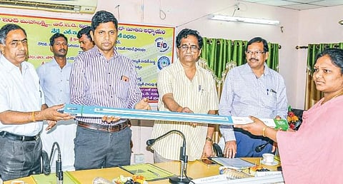 District Collector K Bhaskar distributing LED tube lights to power consumers in Eluru on Thursday | Express