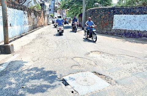 Road dotted with potholes gives hard time to the motorists at Anthony Nagar in Visakhapatnam | Express