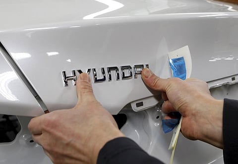 A worker fixes the Hyundai logo on a vehicle at a plant of Hyundai Motor in Asan, south of Seoul. (File | Reuters)