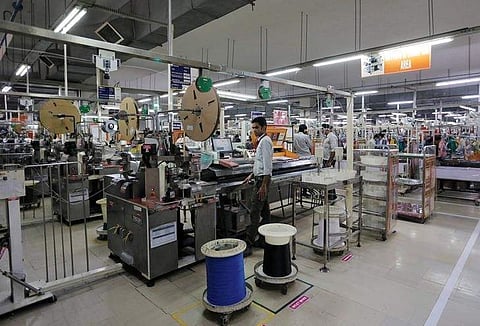 Employees of Motherson Sumi Systems Ltd, work on a car wiring assembly line inside a factory in Noida. (File | Reuters)