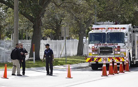 Authorities stand outside the entrance to the David Posnack Jewish Community Center and David Posnack Jewish Day School after people were evacuated because of a bomb threat. AP
