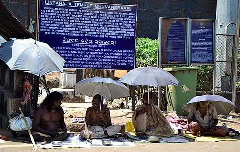 Beggars take cover from the scorching sun under umbrellas near Lingaraj temple on Wednesday | Express